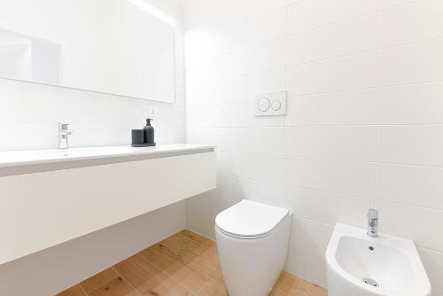 Baño blanco con aseo y lavamanos en Milleventi Apartments, en Bolonia