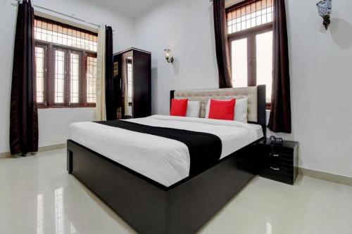 a bedroom with a large bed with red pillows at Elegance Resort in Jait
