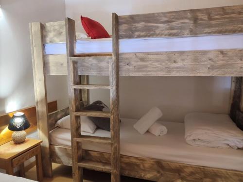 a bedroom with two bunk beds with a ladder at Chalet Hôtel Les Blancs in Pra-Loup
