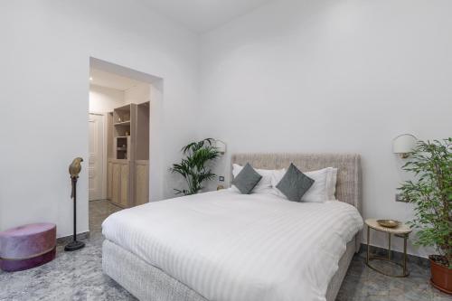 a bedroom with a large white bed with plants at Duomo Smart Suites in Milan