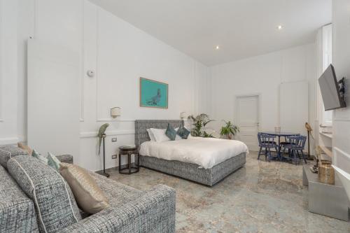 Duomo Smart Suites في ميلانو: غرفة معيشة مع سرير وأريكة