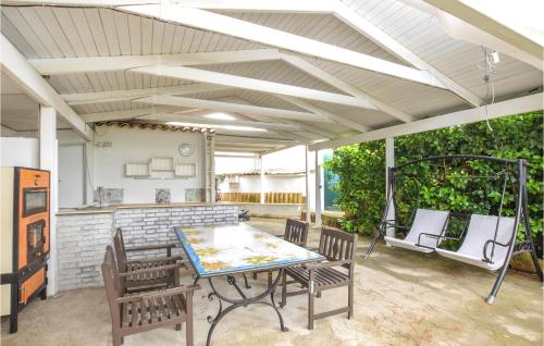 a patio with a table and chairs and a swing at 4 Bedroom Lovely Home In Caltagirone in Caltagirone