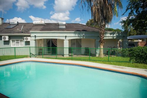 a large swimming pool in front of a house at Haithoms Guesthouse in Gaborone