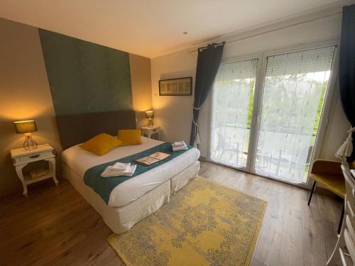 a bedroom with a bed and a large window at Domaine Du Moulin Vallée Heureuse in Poligny
