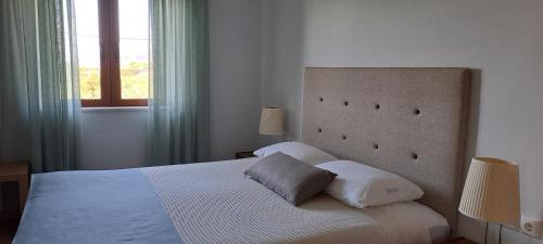 ein Schlafzimmer mit einem großen Bett und einem Fenster in der Unterkunft Viena Rooms & Apartments in Palaiochóra