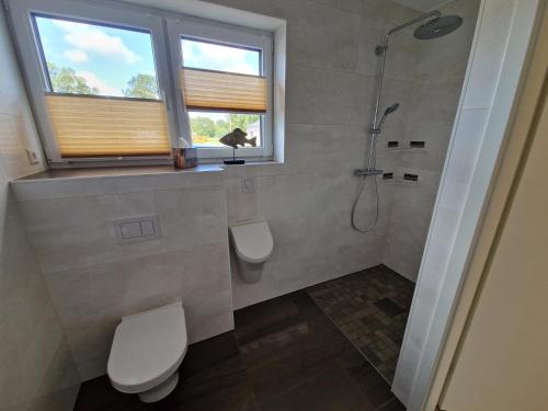 baño con ducha y aseo y ventana en Apartment nahe Meyer Werft in Ostfriesland mit Küche & Netflix, en Westoverledingen