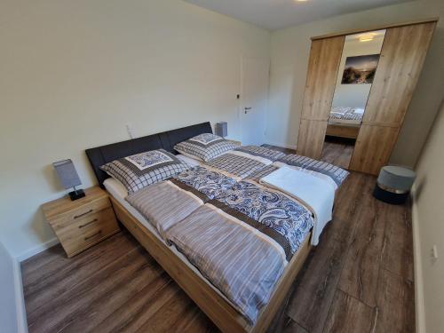 1 dormitorio con 1 cama grande y suelo de madera en Apartment nahe Meyer Werft in Ostfriesland mit Küche & Netflix, en Westoverledingen