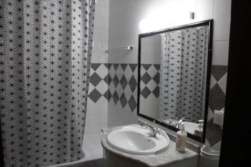 a bathroom with a sink and a mirror at Stay Porto Côvo in Porto Covo