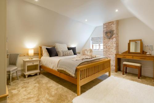 a bedroom with a bed and a dresser and a mirror at Vine Cottage 