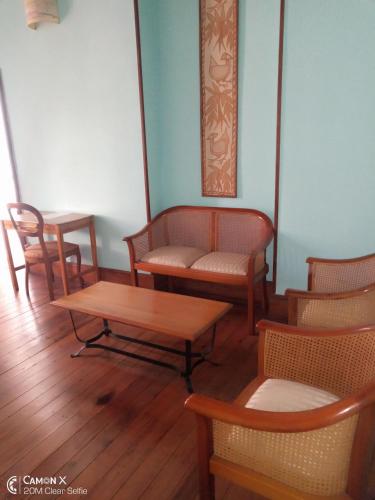 a room with chairs and a table and a bench at Le Manoir in Antananarivo