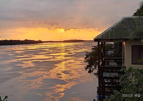 a house with a view of the water at sunset at EL DORADO POUSADA in Barcelos