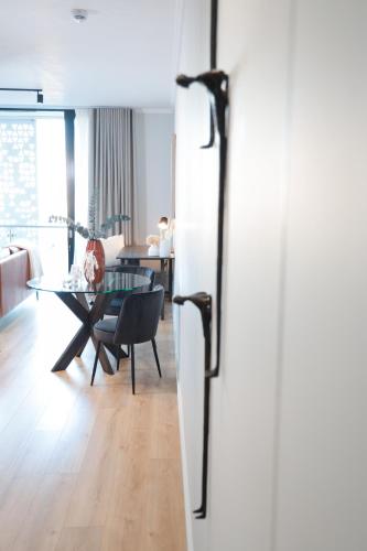 a living room with a table and a dining room at Luxury Apartment at Ellipse Waterfall, Midrand Near Mall of Africa in Midrand