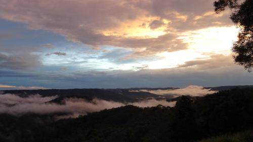 a view of a valley of clouds in the mountains at Maleny Luxury Cottages in Maleny
