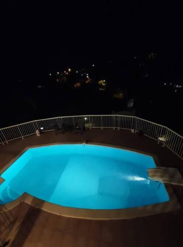 a large blue pool on a deck at night at Bas de villa spacieux, proche plages et centre in Schœlcher