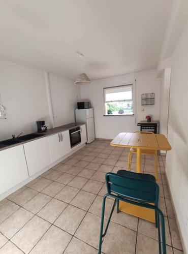 a kitchen with a table and a table and a chair at Bas de villa spacieux, proche plages et centre in Schœlcher