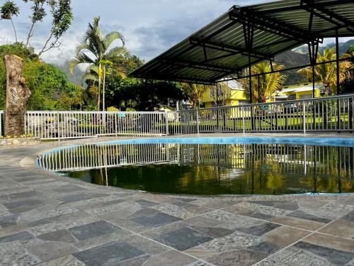 a pool of water with a white fence and trees at Alojamiento Rural Casa de Campo Erika Sofia in Rivera