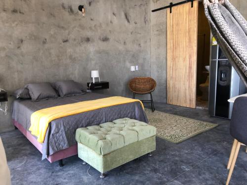 a bedroom with a bed and a chair and a table at Hellen House Bello Horizonte in Santa Marta