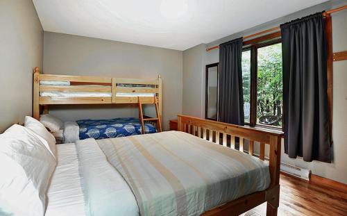 a bedroom with a bunk bed and a window at Chalets Alpins -41 Chemin des Skieurs in Stoneham