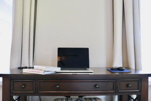 a laptop computer sitting on top of a wooden desk at Glenwood Pines in Flagstaff