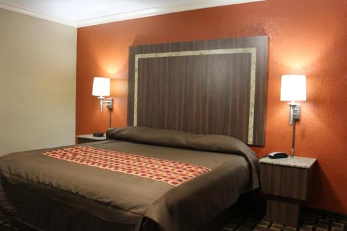 a bedroom with a bed with two lamps on it at Budget Inn Lake Wales in Lake Wales