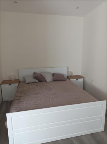 uma cama branca num quarto com duas mesas de cabeceira em Apartment Starfish em Varna City