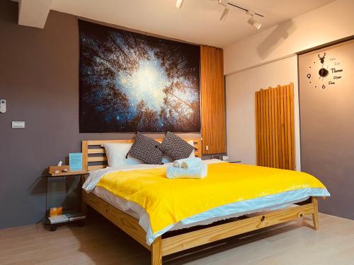 a bedroom with a large yellow bed with a painting on the wall at 墾丁花漾年 小Villa in Hengchun South Gate