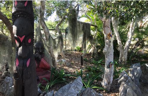 a statue of a woman sitting next to trees at Un Temps Pour Soi in Bouloupari