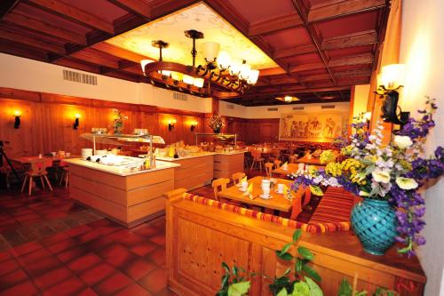 a restaurant with a dining room with tables and flowers at Hotel Weinbauer in Schwangau