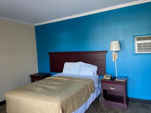 una camera da letto con un letto e una parete blu di Etown Motel a Elizabethtown