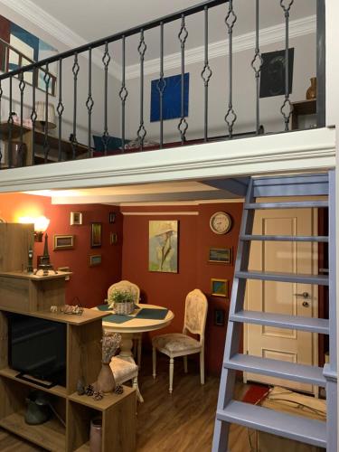 a loft bed with a desk and a table in a room at Aparthotel Mari in Tbilisi City