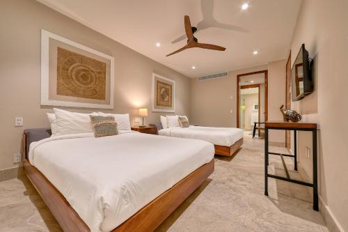 a bedroom with two beds and a ceiling fan at Maxwell Residences at Indah in Puerto Vallarta