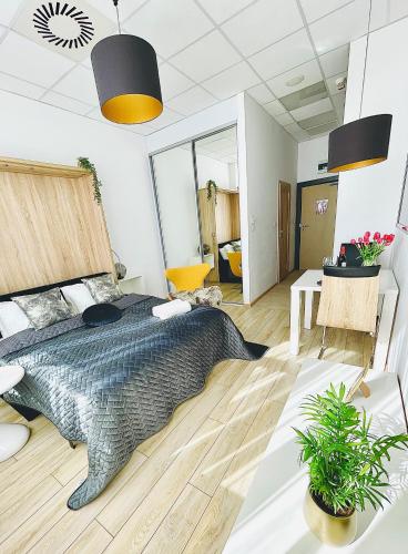 um quarto com uma cama grande e uma mesa em ALE Jerozolimskie Varsovia Apartments em Varsóvia