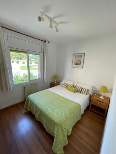 a white bedroom with a bed and a window at Apartamento con Licencia en Sitges in Sitges