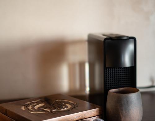 a cup on a wooden table next to a microwave at Puerta del Cielo Hotel Origen in Bacalar