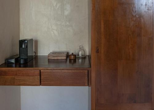 a room with a wooden counter with a microwave and a microwave at Puerta del Cielo Hotel Origen in Bacalar
