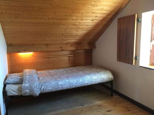 Bett in einem Zimmer mit Holzdecke in der Unterkunft Les mésanges in Rochefort