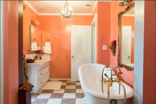 a bathroom with orange walls and a tub and a sink at Hollywood Home in Los Angeles