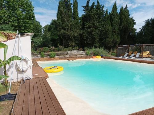 une grande piscine avec un bateau jaune. dans l'établissement Domaine Le Piboul, à Fontcouverte