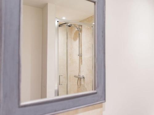 a bathroom with a shower with a mirror at Norwood Dairy in Bredgar