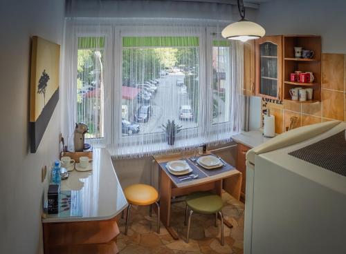 cocina con mesa, sillas y ventana en Komfortowy Apartament Seven niedaleko centrum, en Olsztyn