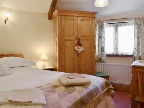 a bedroom with a large bed and a wooden cabinet at Swallows Return in Whitehaven