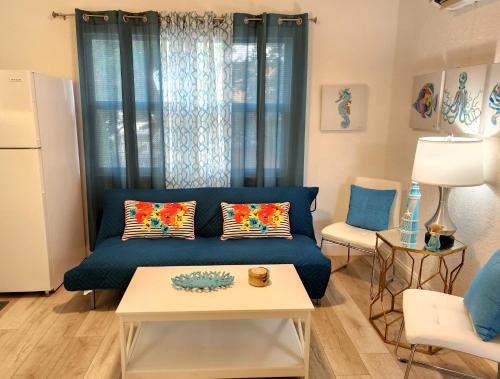 a living room with a blue couch and a table at Mermaid's Lighthouse in West Palm Beach