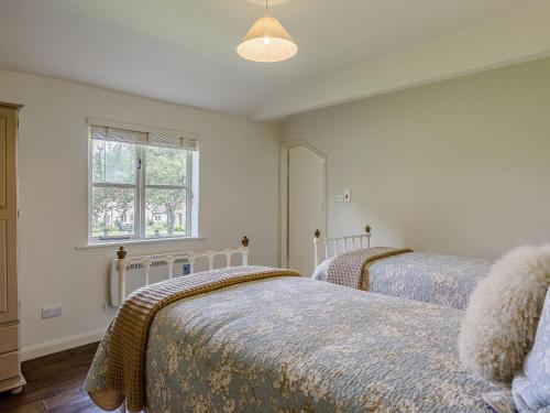 um quarto com 2 camas e uma janela em Orchard Barn em Meare