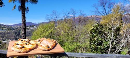 two pastries on a wooden cutting board with a view at I Vallata Paradise I EV outlet & Free Parking - 10 minutes from Lugano with a big Garden&View in Lugano