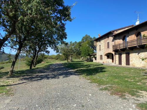 a dirt road next to a building with trees at Agriturismo cergallina in Vernasca