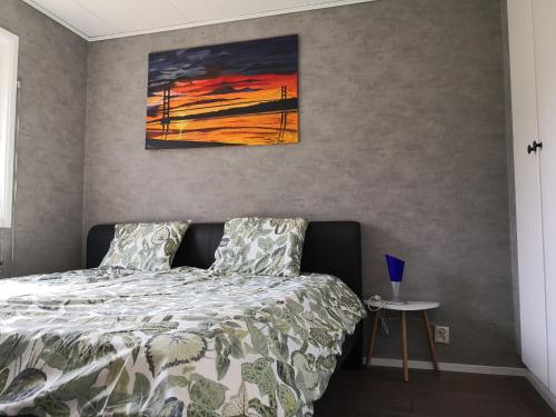HållnäsにあるFerienhaus Vikeberg in Mittelschweden am Meerのベッドルーム1室(ベッド1台付)が備わります。壁には絵画が飾られています。