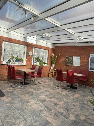 a room with a table and chairs and a brick wall at Pension am Meer in Norddeich