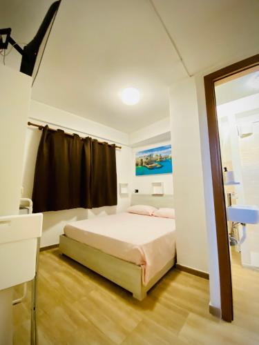 um quarto branco com uma cama e uma janela em Petite room em Noicattaro