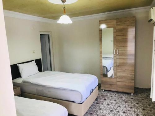 Habitación de hotel con 2 camas y espejo en KARADUT PENSION NEMRUT en Karadut