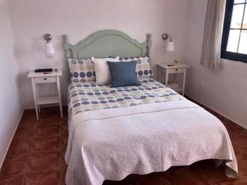 1 dormitorio con 1 cama grande y 2 mesas en Vista Faro Sardina, en Las Palmas de Gran Canaria